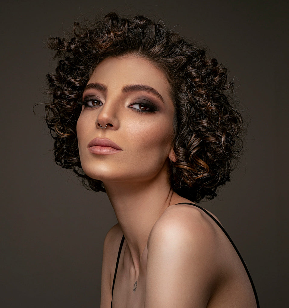 a woman with curly hair wearing a black dress