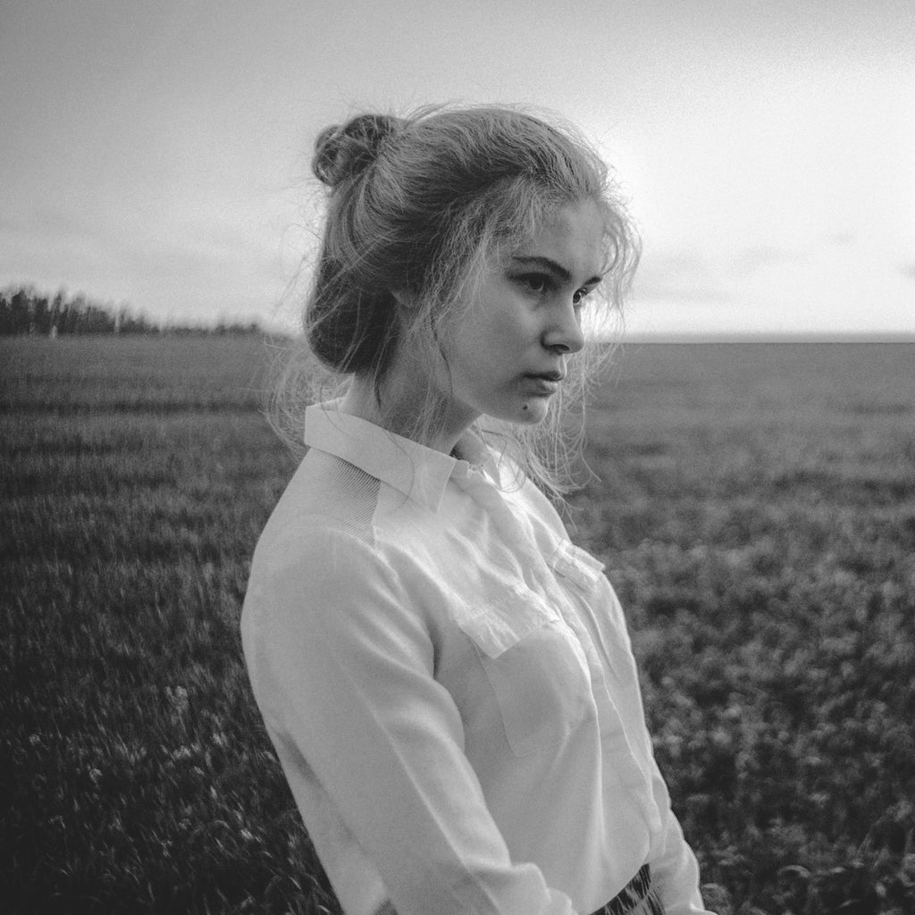 A black and white photo of a woman in a field