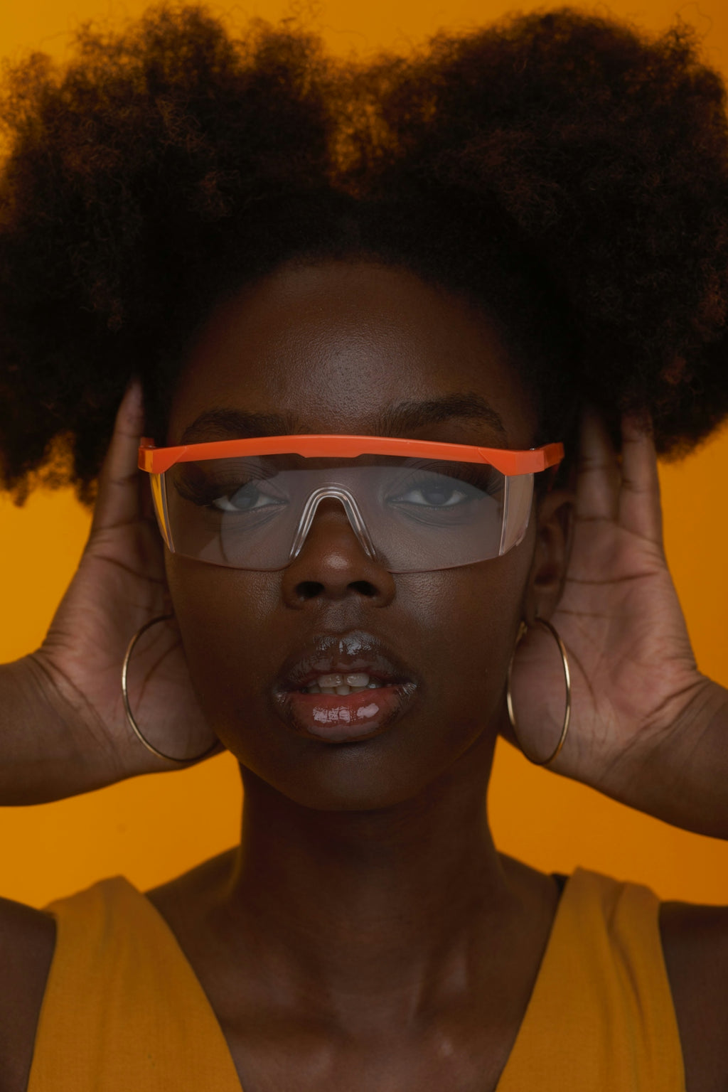 Woman models safety glasses with an expressive look.