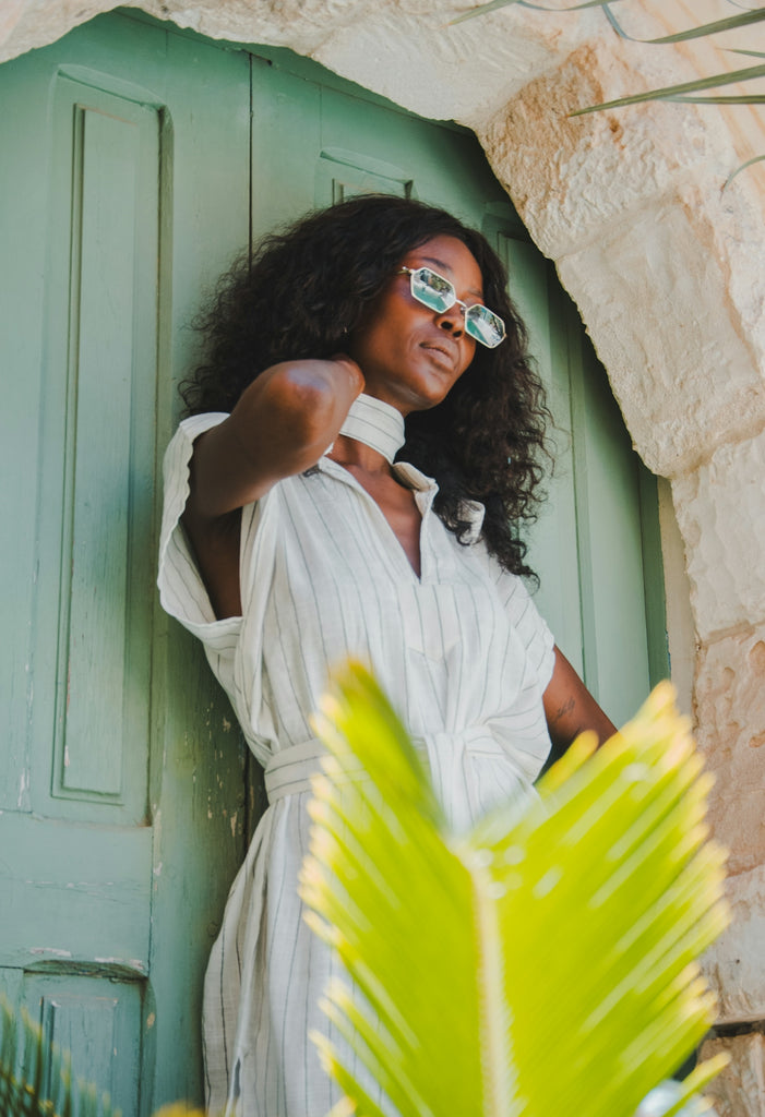 A woman poses near a green door.