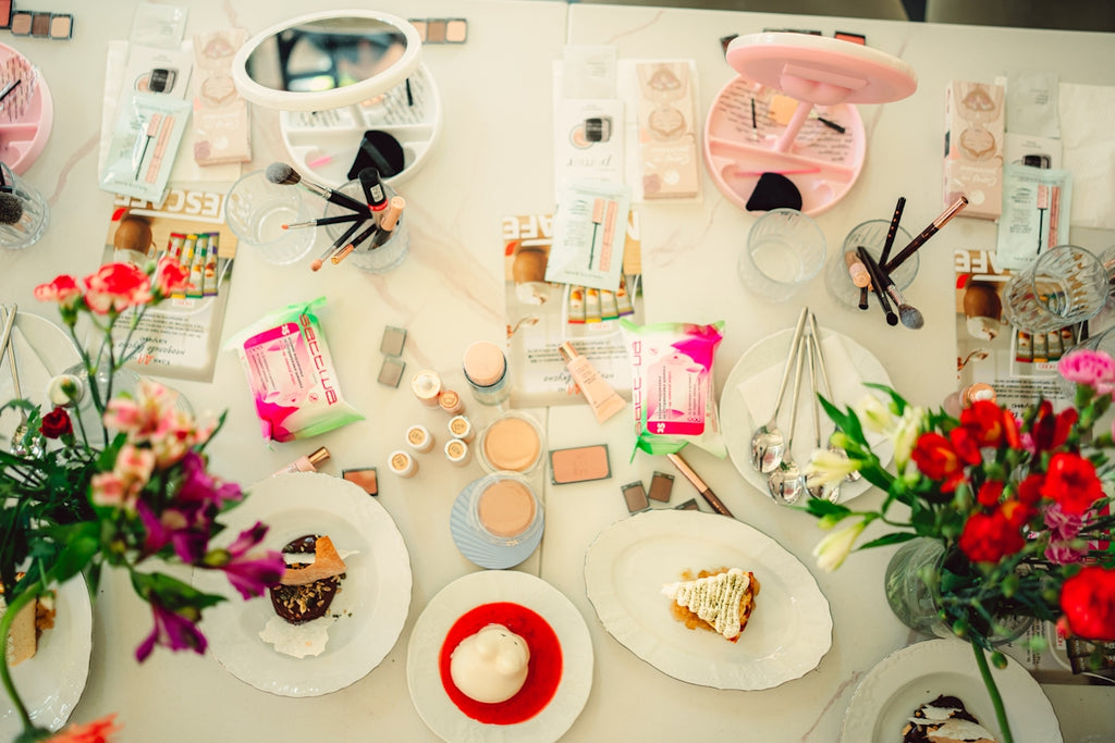 A collection of makeup and desserts on a table.