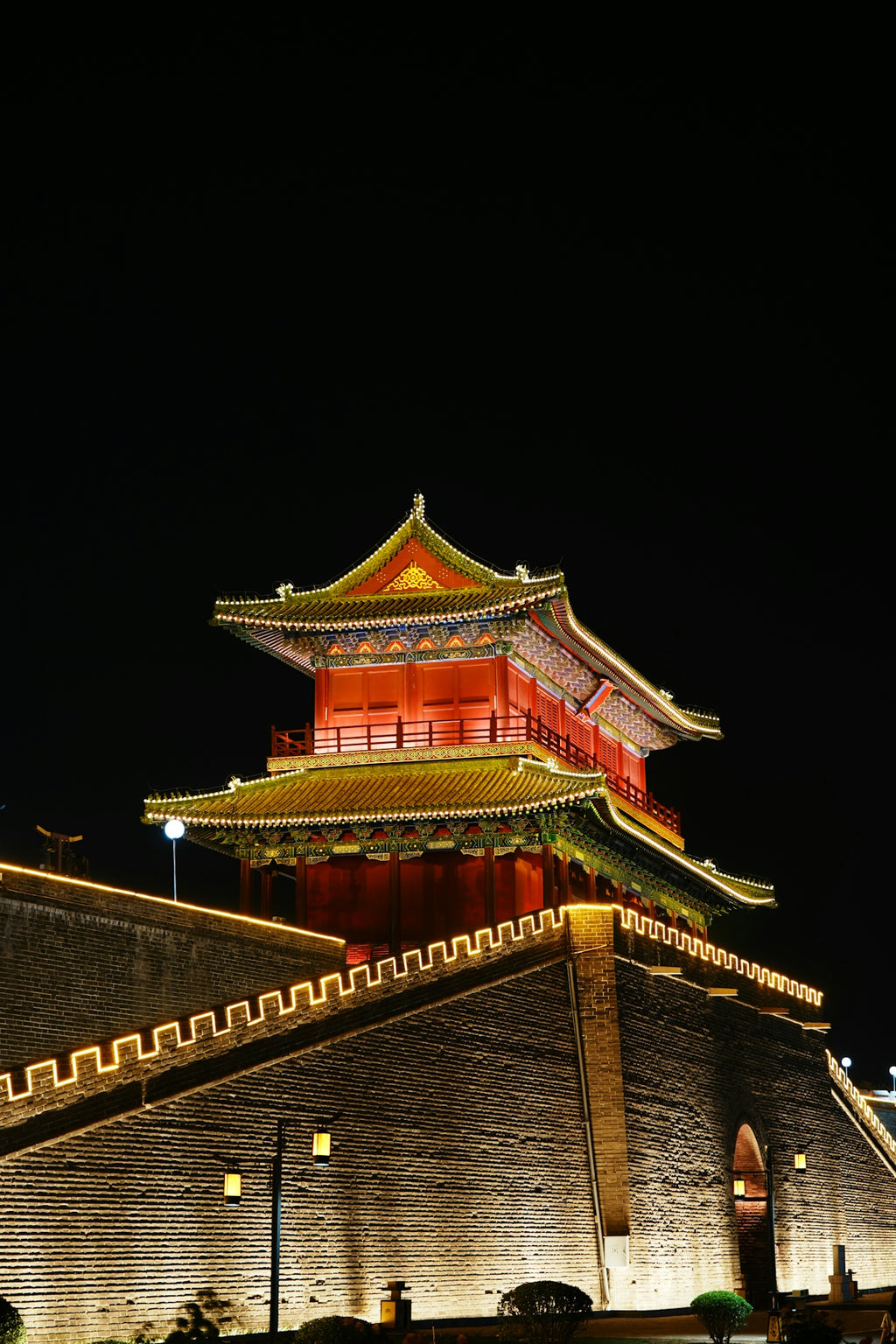Illuminated ancient chinese tower and wall at night.
