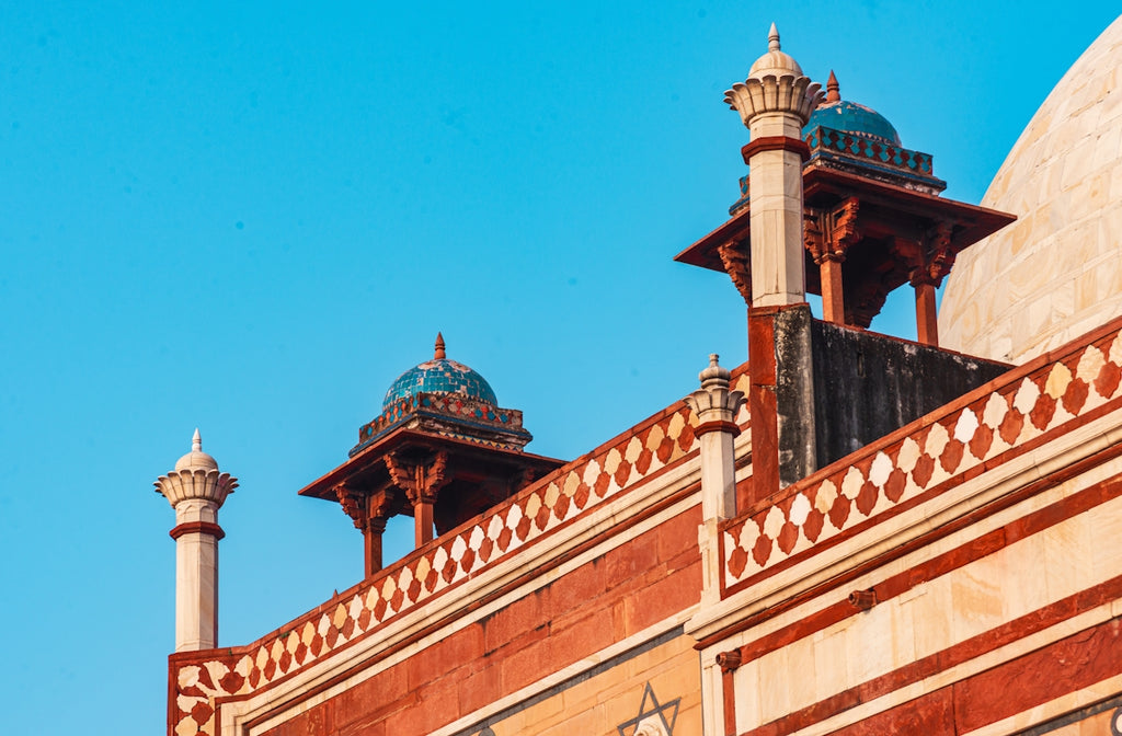Ornate indian architecture against a clear blue sky.