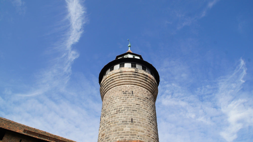 A tall stone tower against a blue sky.
