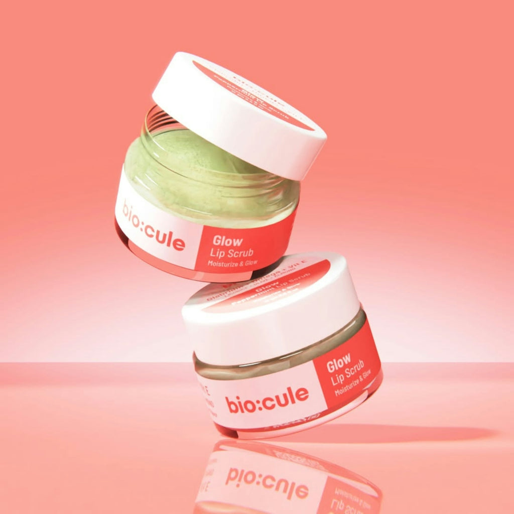 Two jars of lip scrub stacked on a pink surface